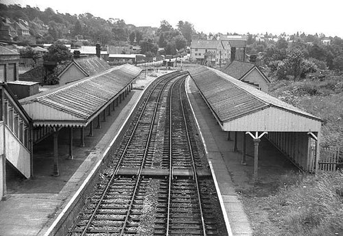 Black and white photograph of a railway station with tracks and platforms.