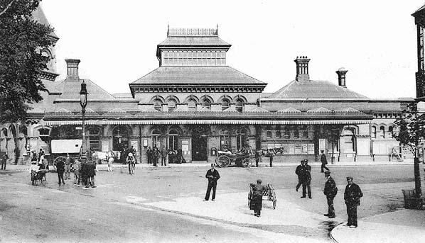 Vintage black and white photograph of a large building with people around it