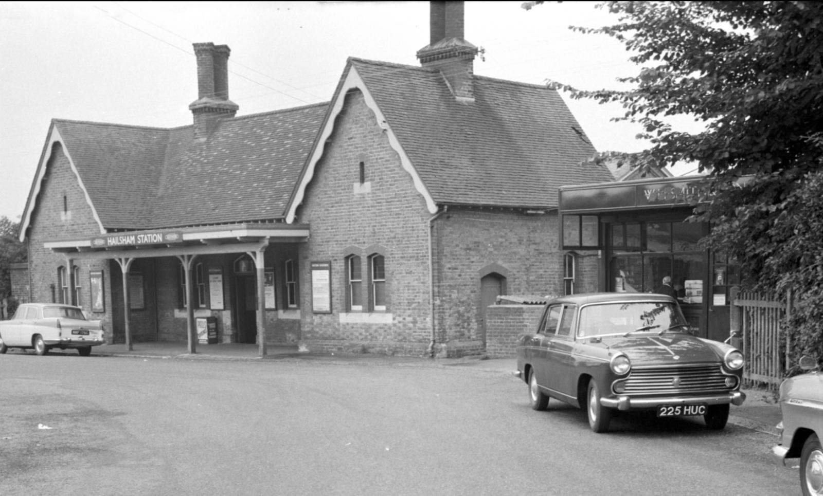 Vintage building with cars parked in front, likely a historical photograph.