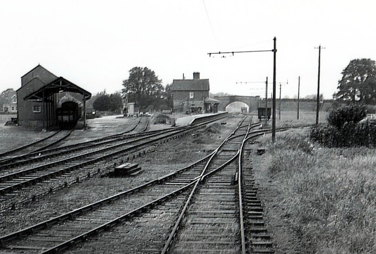 Black and white photograph of a railway yard with multiple tracks and buildings.