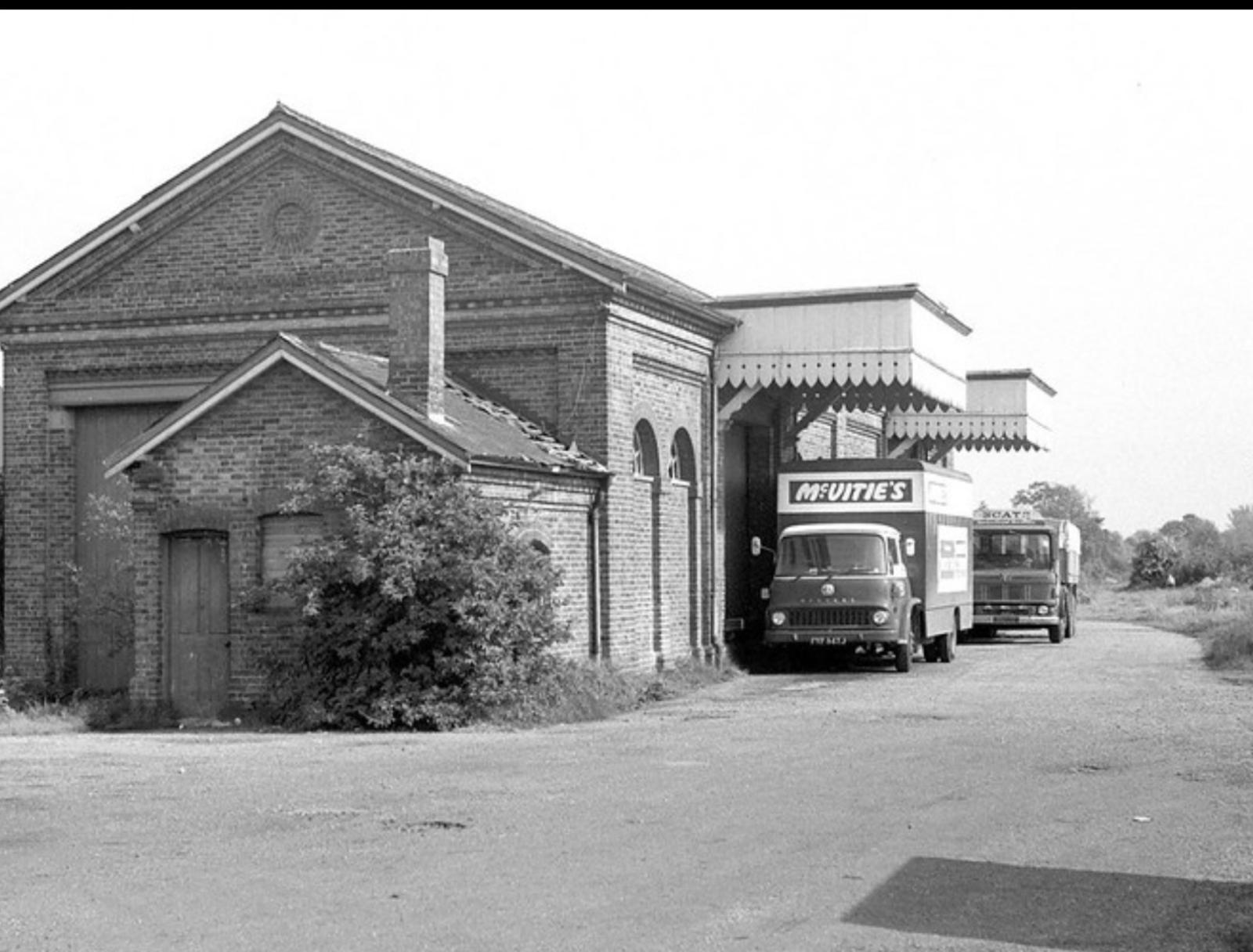 Vintage black and white photo of a building with a truck parked in front