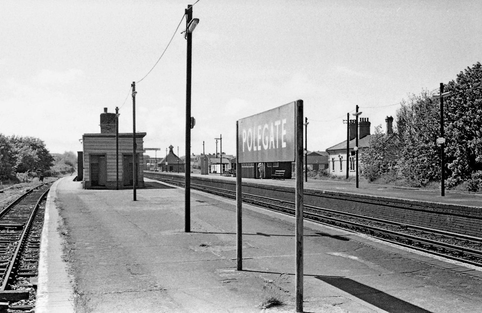 Vintage black and white photograph of a train station platform with 'Polegate' sign.