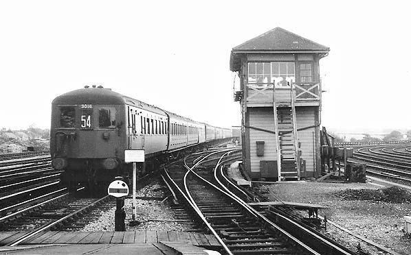 Vintage black and white photograph of a train on tracks with a signal tower.